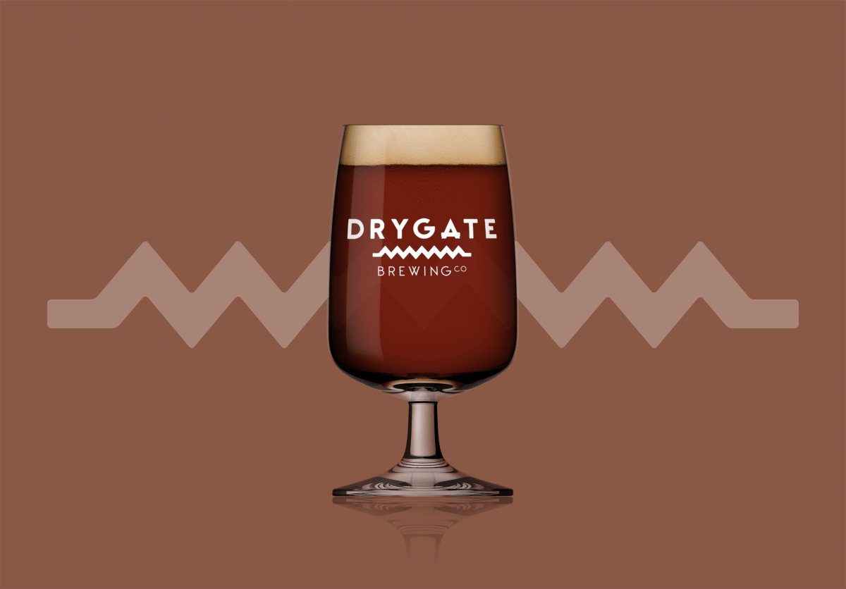 Glass of dark coloured Scotch Ale with brown background